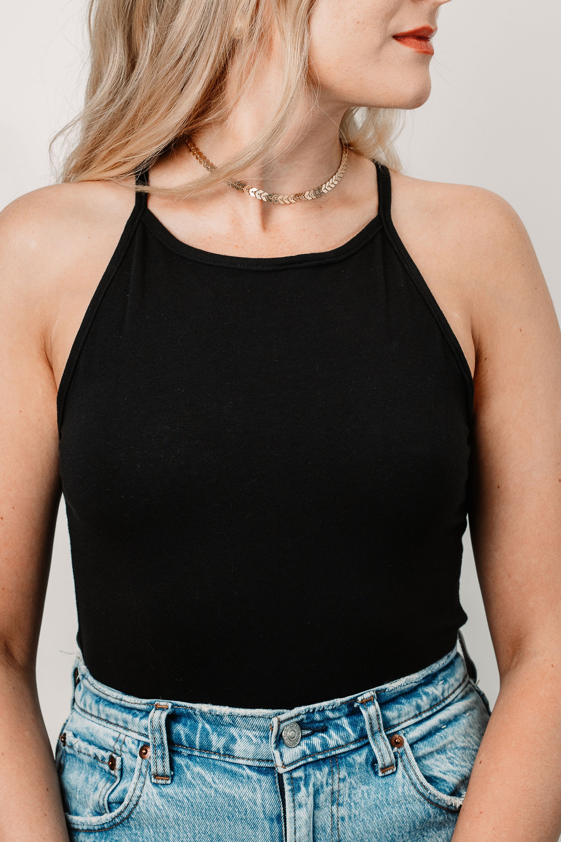 Charlotte wears the Black Willa Bodysuit in size XS. Close up.