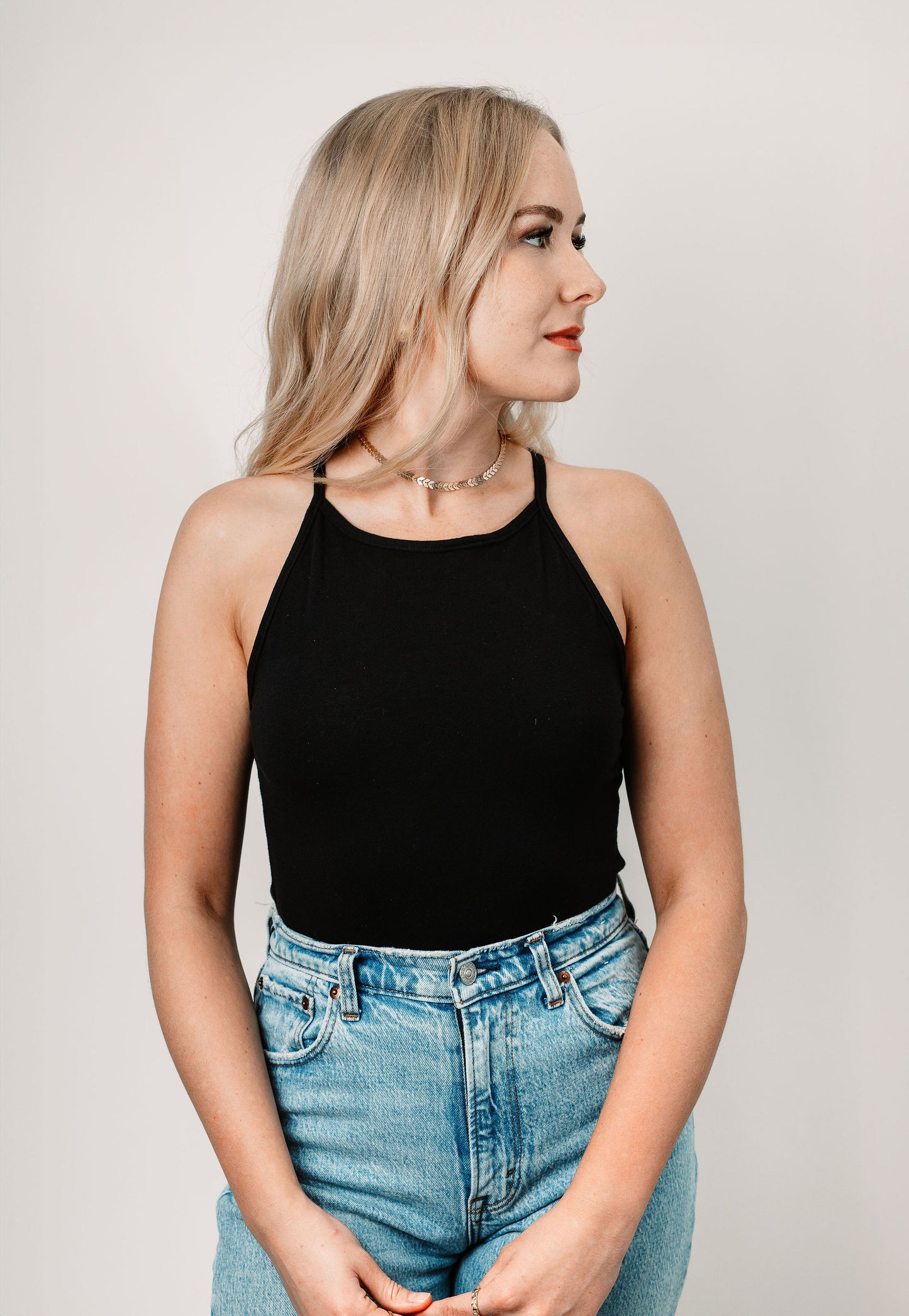 Charlotte wears the Black Willa Bodysuit in size XS. Front view.