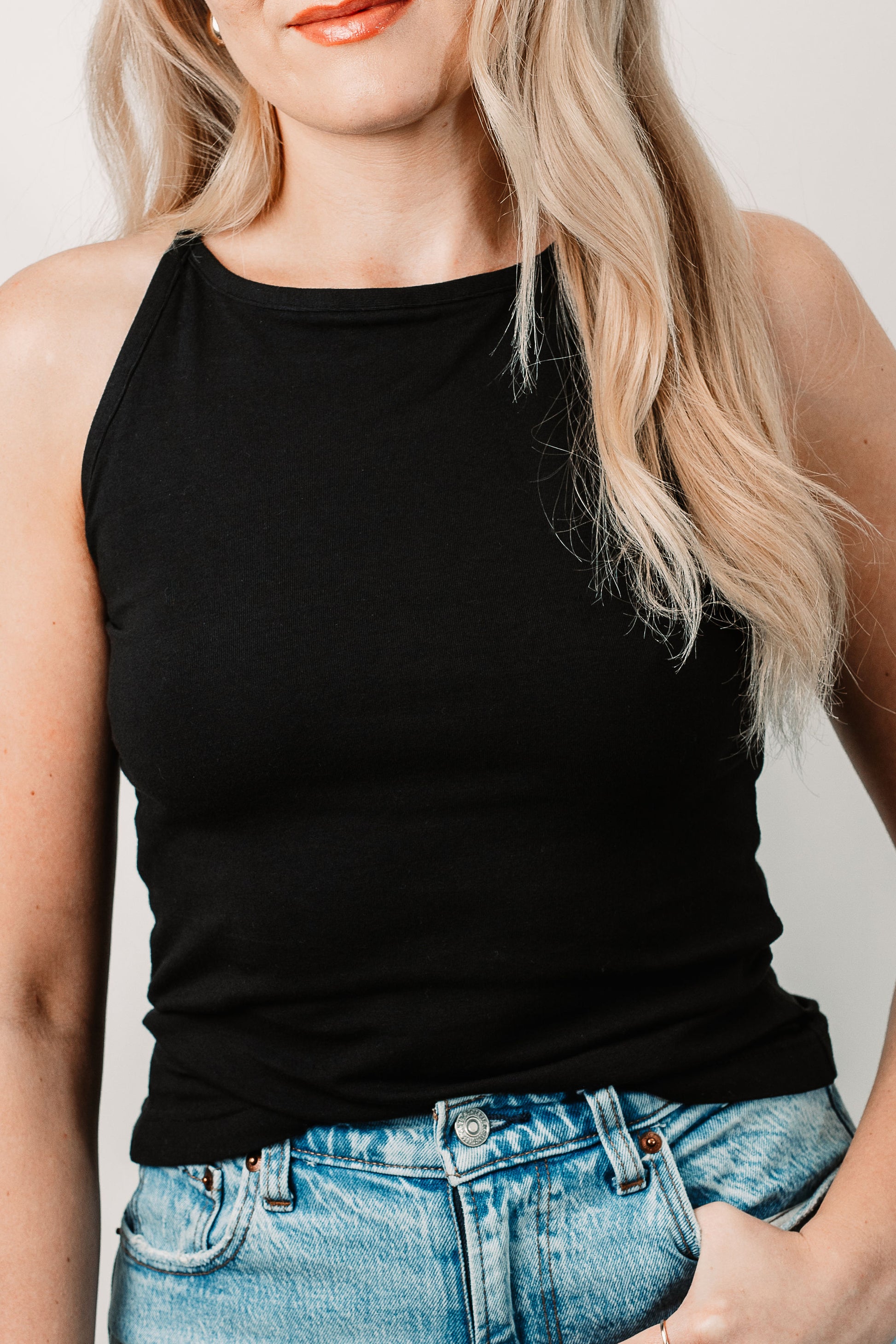 Charlotte wears the Willa High Neck Tank in Black in size XS. Close up.