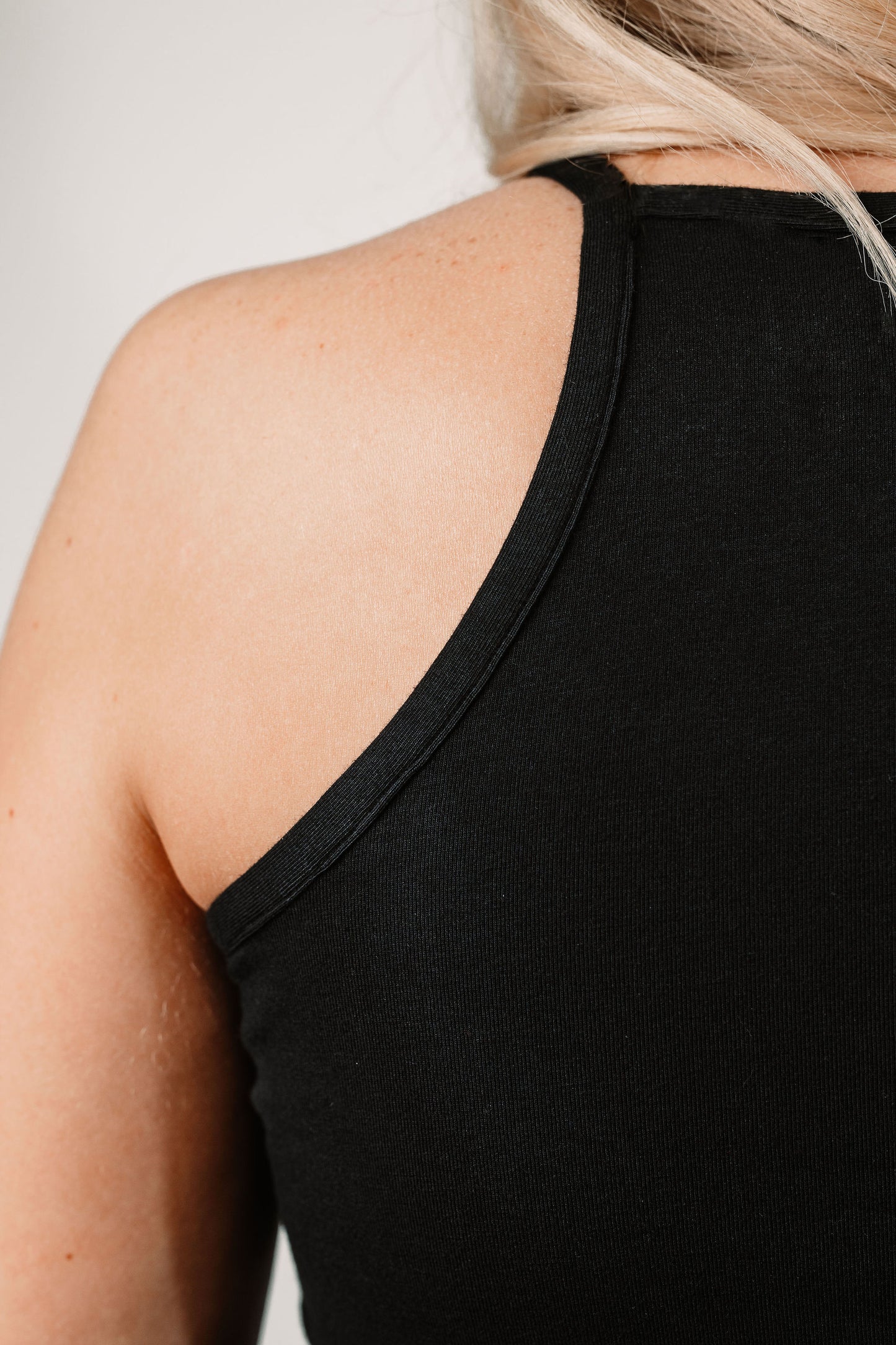 Charlotte wears the Willa High Neck Tank in Black in size XS. Close up.