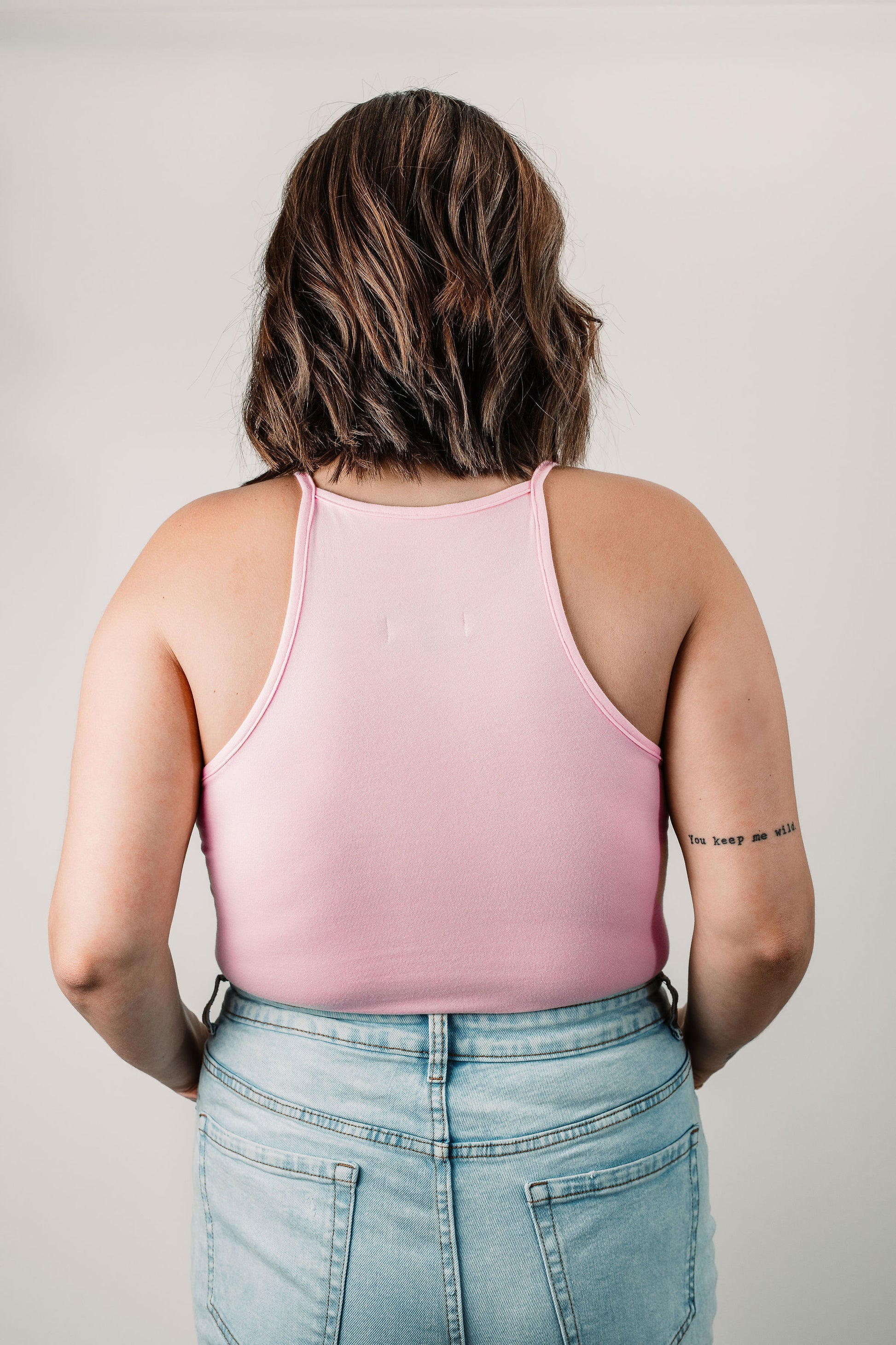 Natalie wears the Baby Pink Willa Bodysuit in size L. Back view.