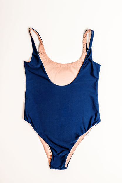 Flat lay of the Sailor Low Back One Piece in navy. Back view.